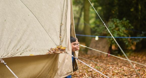 boy looking out of tent