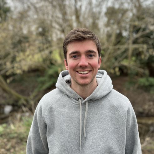 Jamie standing outside with a tree in the background