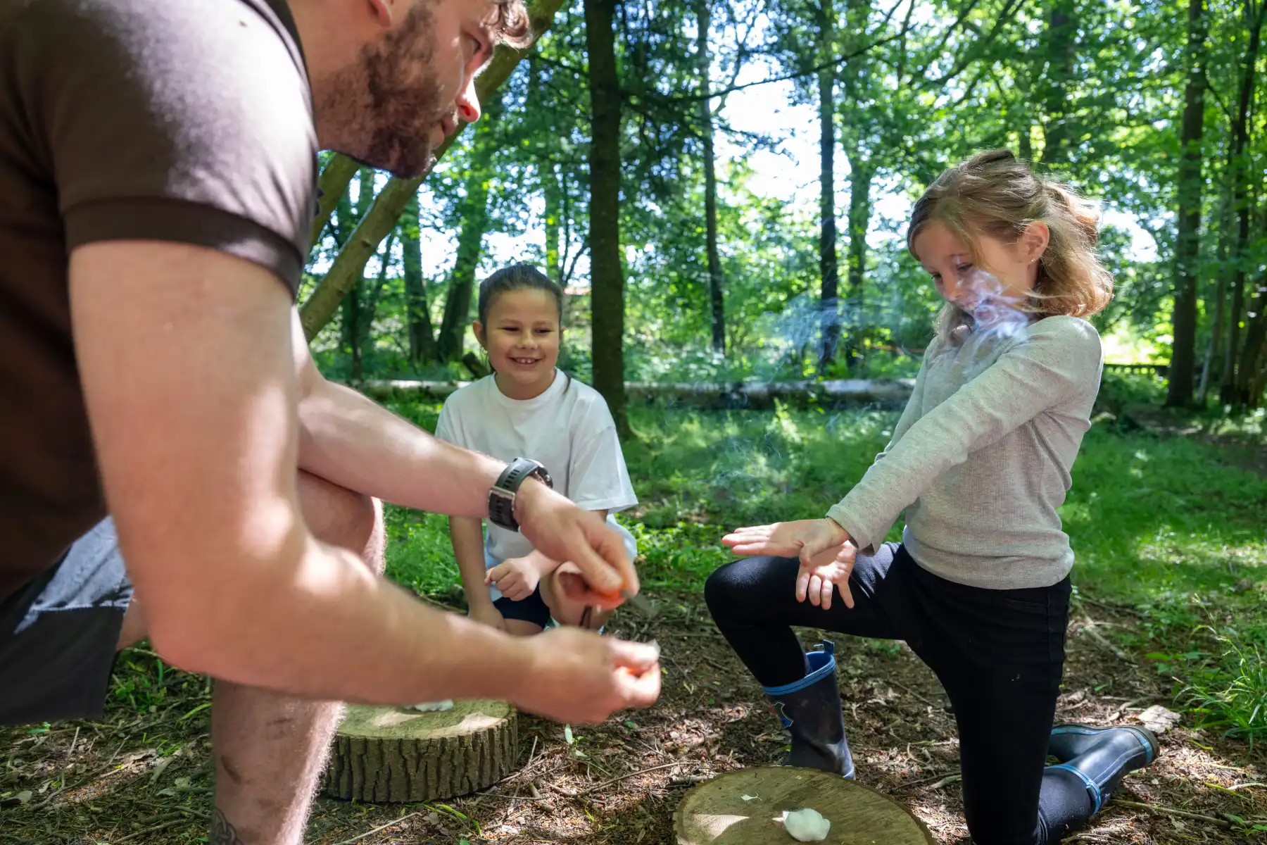 Girls learning firelighting in the woods