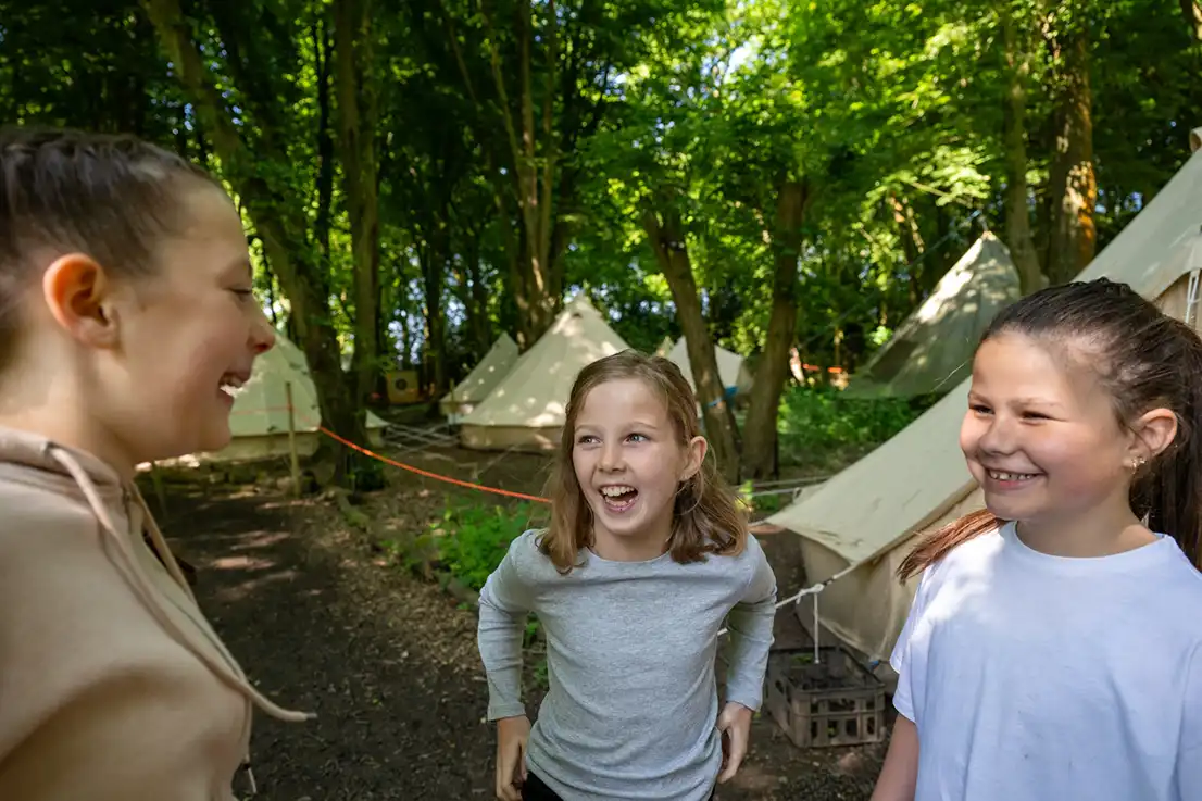 Girls laughing outside tent