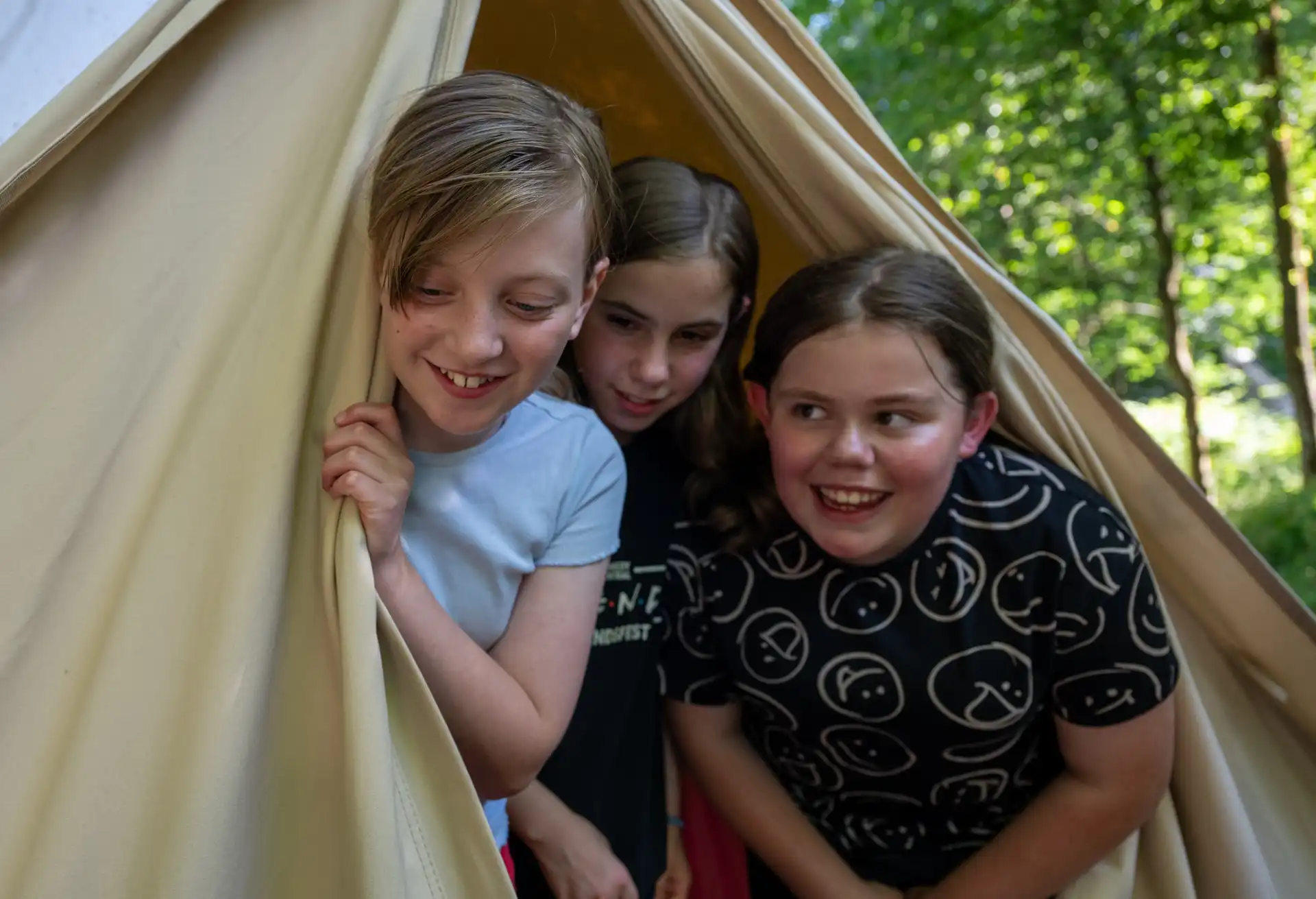 Girls peeking out of tent